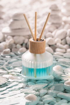 Sophisticated diffuser fragrance on of white stones at sea.
