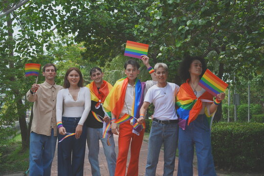 Pride and LGBTQ concept. A transgender man and his LGBTQ friends, who have a good relationship, joined the multinational parade, carrying signs and flags celebrating equal rights for all genders at Pr