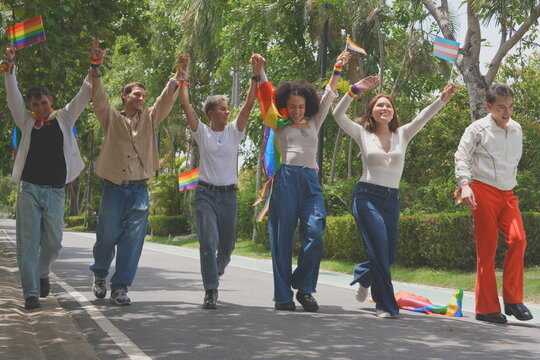 Pride and LGBTQ concept. A transgender man and his LGBTQ friends, who have a good relationship, joined the multinational parade, carrying signs and flags celebrating equal rights for all genders at Pr