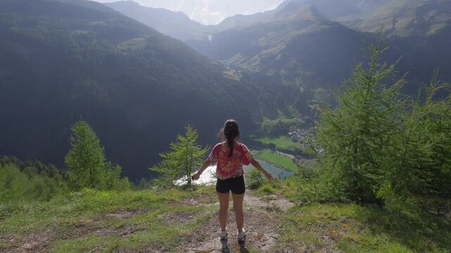 Young European woman standing on a mountain overlooking Spluga valley Italy Lago Di Isola