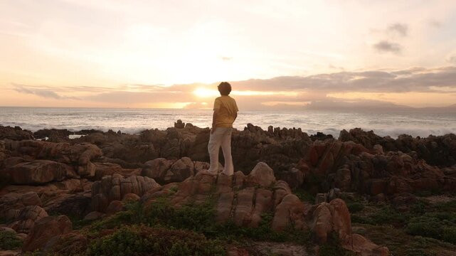 young boy exploring rocky coastline of DeKelders, Gansbaai, South Africa