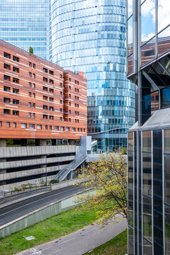 Glass tower architecture rises over a Paris France urban road, where business district facade reflections frame transport and city depth