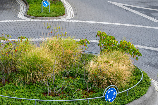 Roundabout landscaping softens an urban road in Frankfurt Germany, where green transport markings and city planning shape ordered detail