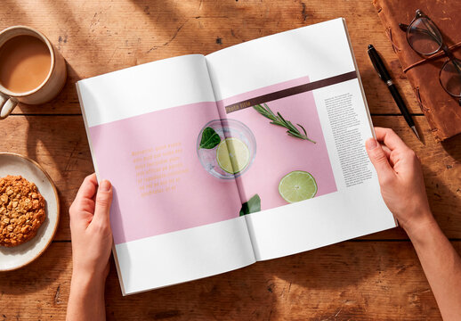 Hands holding open blank book on rustic wooden desk