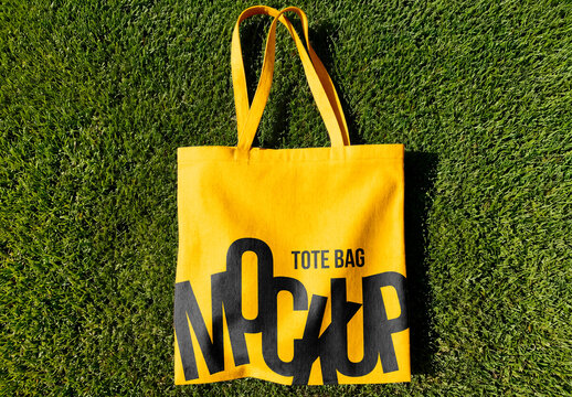 Canvas tote bag lying on green grass outdoor minimal eco lifestyle