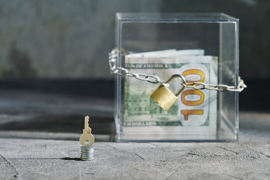 Locked USD Assets in Secured Transparent Cube with Standing Key for Business Audit Concept and Copyspace