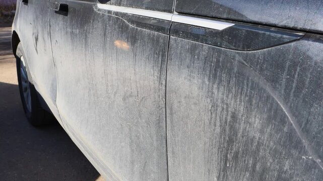 Extremely dirty dusty car covered of mud and grime, filthy vehicle outdoors close-up