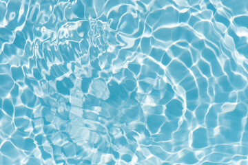 Obraz premium Blue water with ripples on the surface. Defocus blurred transparent blue colored clear calm water surface texture with splashes and bubbles. Water waves with shining pattern texture background.