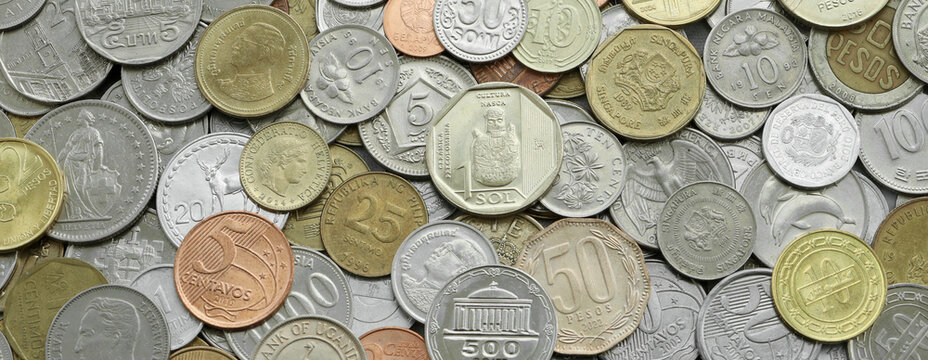 Top view of assorted coins, numerous world currencies together. Shiny metal pieces in mound