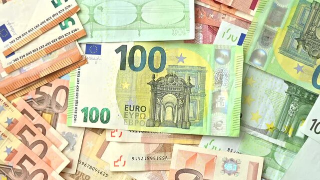 Pile of euro banknotes in different denominations including 100 and 50 euro bills creating a rich financial background.