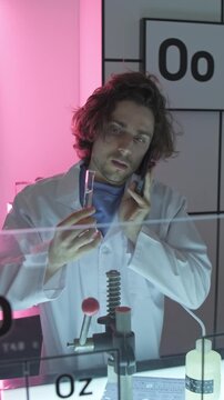 Dubai, UAE - 07 07 2025: Male scientist examining test tube in laboratory with neon lighting