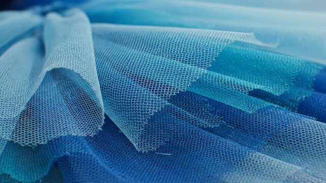Close-up of layers of blue tulle fabric showing a gradient effect of shades for fashion or decorative purposes
