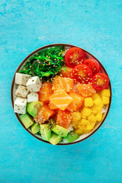 Salmon poke bowl with mango, avocado, tofu, wakame, cherry tomatoes