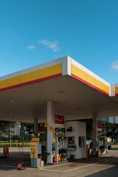 Tangerang, Indonesia, 18 May 2026. Empty Shell gas station with red and yellow canopy and fuel pumps on a sunny day with clear blue sky, illustrating the petroleum industry.