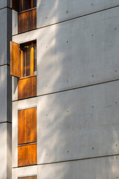 Wooden shutters add warm detail to a Lyon France apartment building facade, where concrete panels frame residential windows and architecture