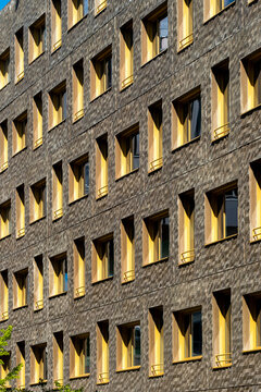 Stone texture catches warm windows on a Lyon France apartment building facade, giving urban architecture a measured residential pattern