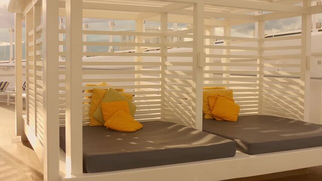 Sunlit cabana beds with yellow cushions on a quiet cruise ship outdoor deck area