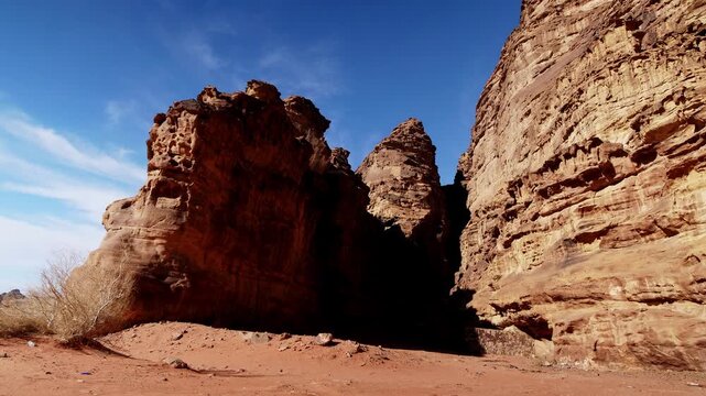 Daytime timelapse of the red sandstone rock formations in Wadi Rum, Jordan. Clouds moving over the desert landscape of the Valley of the Moon, a UNESCO World Heritage site in the Middle East