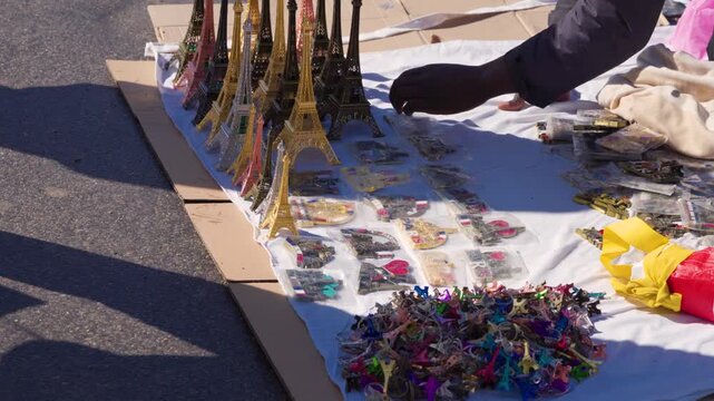 Illegal Street Vendor Selling Eiffel Tower Souvenirs Near Landmark In Paris France, Close Up Of Merchandise On Ground &mdash; static street shot