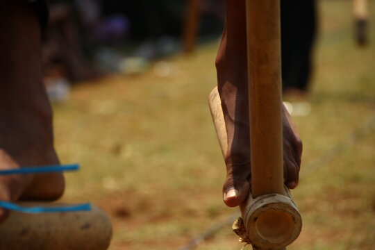 Bare feet balance on bamboo egrang stilts during a traditional Indonesian outdoor competition