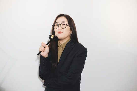 female lawyer in suit at workplace with laptop, gavel and femida in office