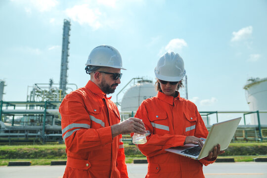 Oil and gas refinery in petroleum industry with inspection engineer, industrial engineer plant inspection safety helmet laptop refinery workers