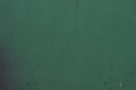Distressed green metallic texture background with scratches and rust spots, space for text.Aged weathered iron surface painted in dark green color, grunge metal background