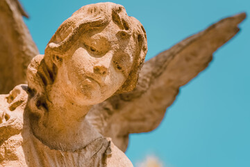 Fototapeta premium Beautiful stone angel statue against bright blue sky, symbolic image of heaven, peace and spiritual protection