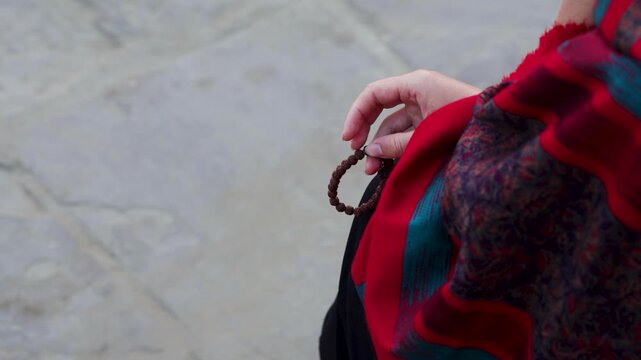 women performing Rudraksha Japa with bracelet and red shawl during spiritual meditation moment