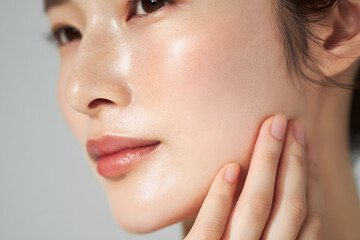 毛穴やシワのある肌に触れる日本人女性のクローズアップ(美容イメージ)