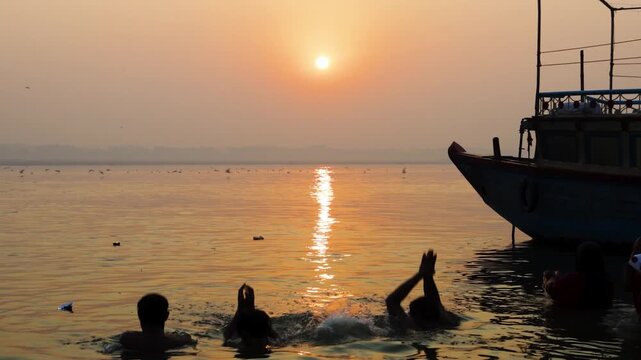 silhouettes of devotees praying in holy ganges river during chhath festival spiritual ritual