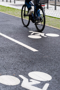 Motion blur follows a cyclist on a Lyon lane, where asphalt, road marking, symbol, commute and mobility repeat across the cycling route.