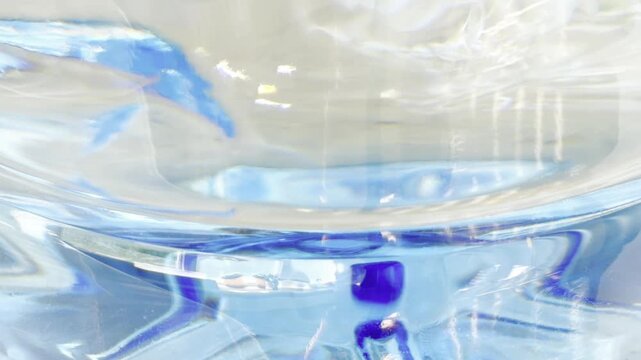 Abstract blue ink swirling in pure water, creating a mesmerizing dance of color and light as the liquid mixes and disperses, forming delicate patterns and textures