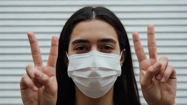 Starting holding hands forming peace signs, woman with white mask posing to lens at ribbed shutter