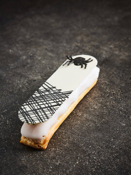 A gourmet eclair features a delicate cream filling and a unique black and white decoration on top. This pastry is ideal for upscale restaurant menus, dessert cafes, and luxury food events