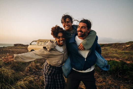 Friends posing together outdoors at sunset
