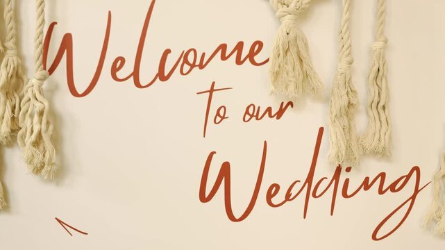 Wedding welcome text lettering message close up on a beautiful elegant calligraphy sign board. Slow motion typography close up of a handwritten marriage greeting banner.