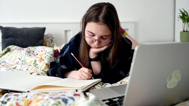 Teenager diligently reviewing study material at organized desk with deep concentration, dedicated student preparing for exam or class assignment at home workspace showing evening academic discipline