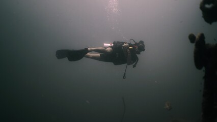Scuba diver exploring deep murky water, enjoying underwater adventure © FranciscoJavier