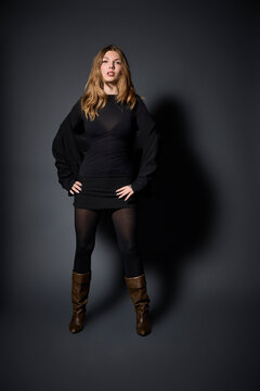 Confident Young Woman Posing Against a Dark Background