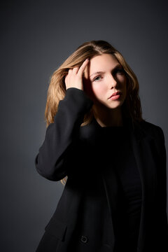 Confident Young Woman Posing Against a Dark Background