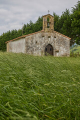 Fototapeta premium Old rural chapel surrounded by trees and grass.