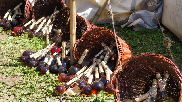 Medieval market stall with fruit wine in wicker baskets