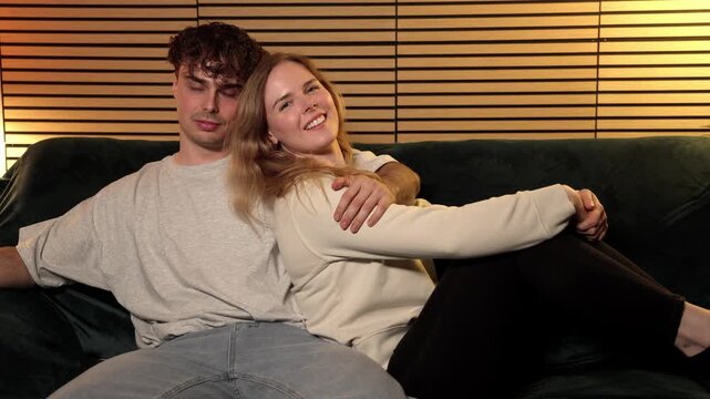 Couple love and affection, a young man and woman cuddling on a sofa at home. This clip captures the essence of a romantic relationship and togetherness, commercial and editorial projects focusing on d