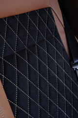Naklejka premium Texture background of a luxury car seat with quilted black alcantara fabric and light diamond stitching.