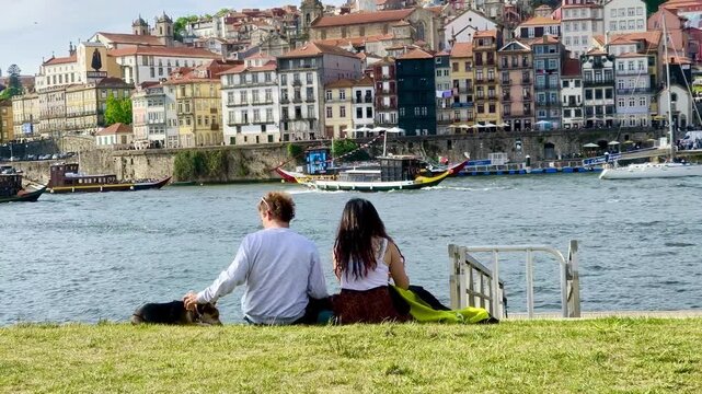 Pareja de espaldas sin rostro se acarician a orillas del rio Duero en Oporto 