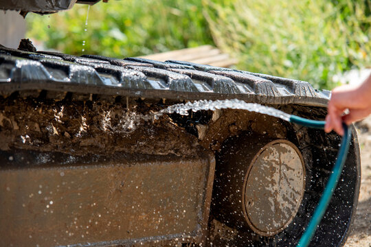 Cleaning the tracks of an agricultural machine in an outdoor field during a sunny day