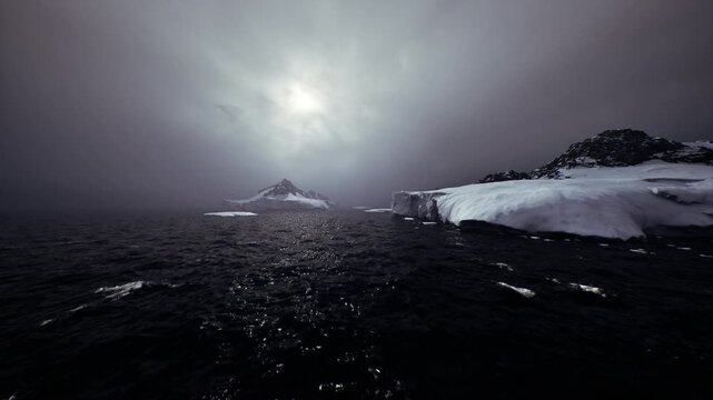 Low pale dawn over sea and fractured ice, small iceberg field, distant massif silhouette, reflective water path guiding imaginary vessel, quiet anticipation,