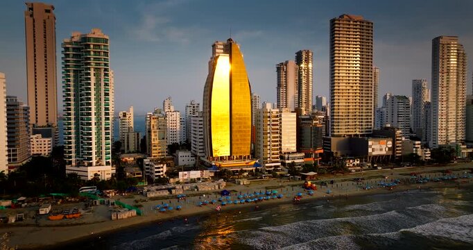 Modern skyscrapers, hotels and beach in Bocagrande district during golden hour in Cartagena, Colombia. Aerial drone lateral view