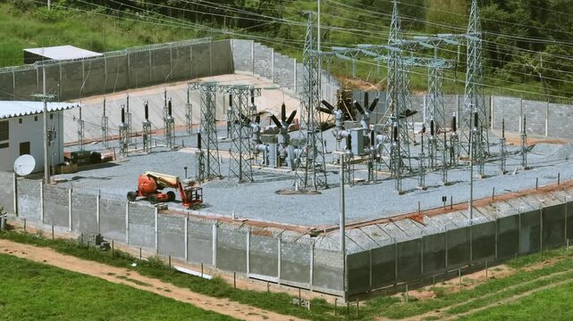 High voltage electrical substation with transformers, switchgear and transmission infrastructure near Santo Ant&ocirc;nio do Monte, Minas Gerais, Brazil surrounded by pastureland, drone pullback parallax